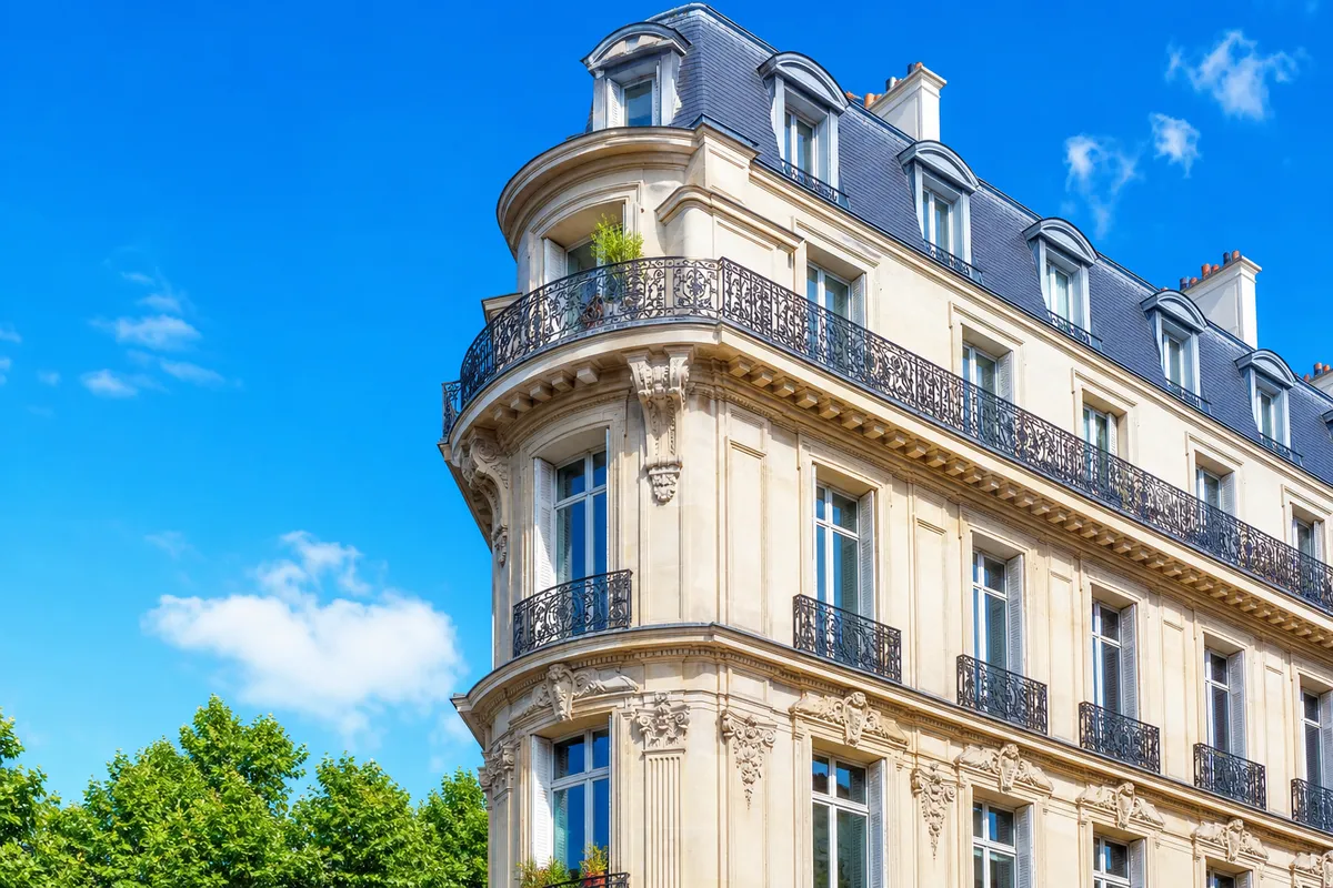 Façade d'immeuble ancien en copropriété sous un ciel bleu