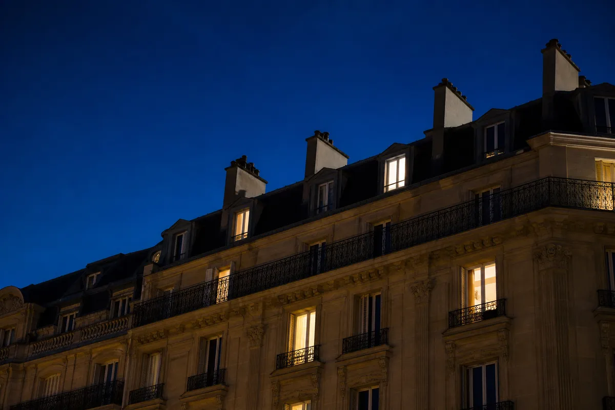 Immeuble de copropriété la nuit, fenêtres éclairées