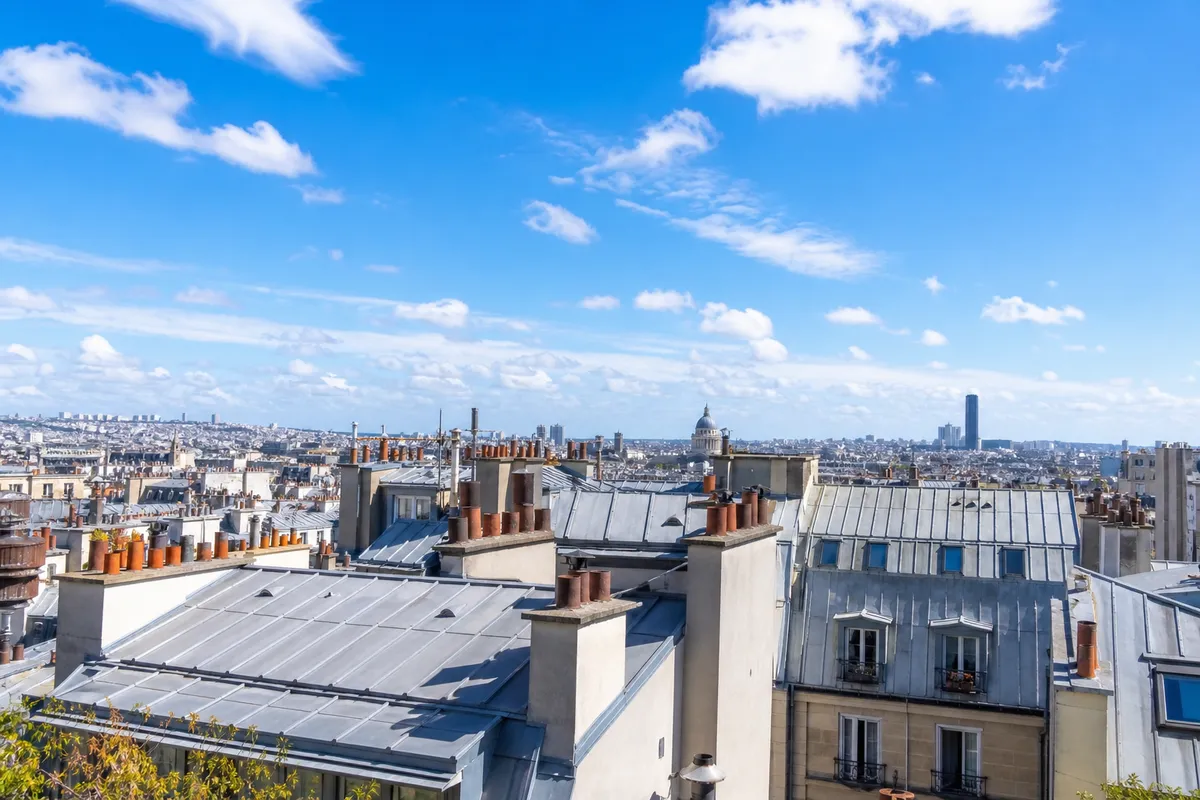 Toits en zinc de Paris sous un ciel bleu éclatant